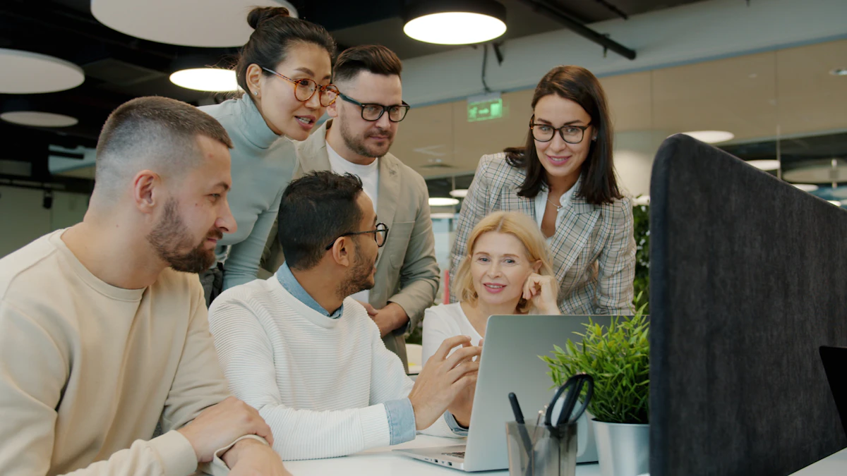 Colleagues collaborating around a laptop in a bright office.