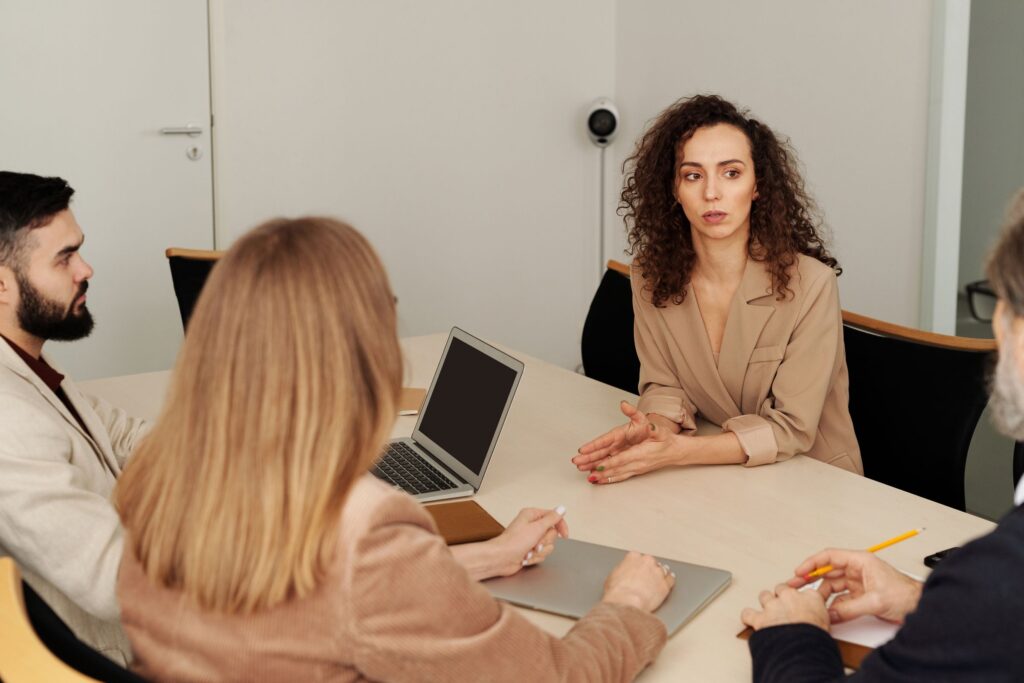 Professionals having a focused conversation around an office table.
